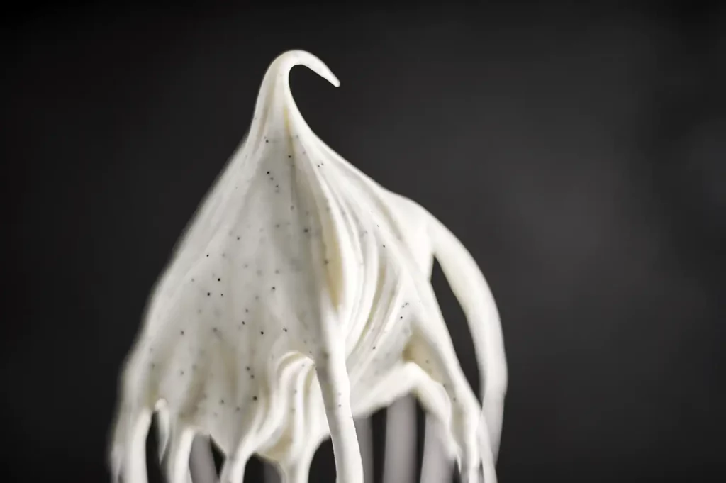 Fouet de Kitchen Aid recouvert de crème fouettée blanche et onctueuse