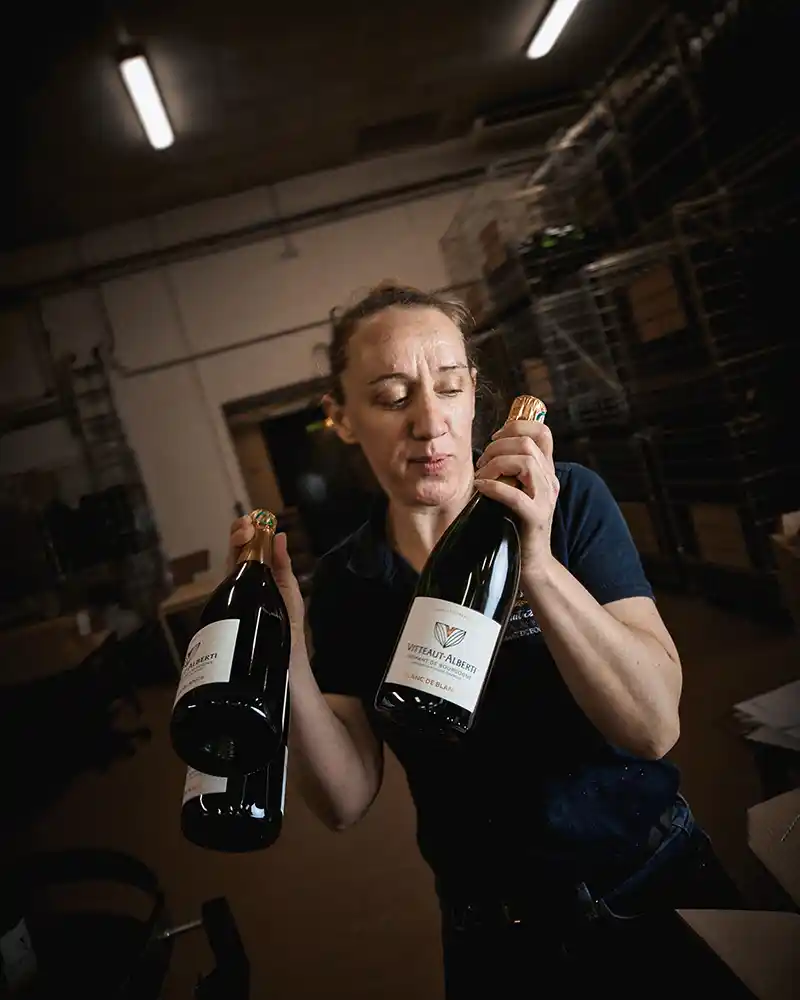 Portrait au poste de travail avec deux bouteilles de crémant de Bourgogne, reportage Vitteaut-Alberti