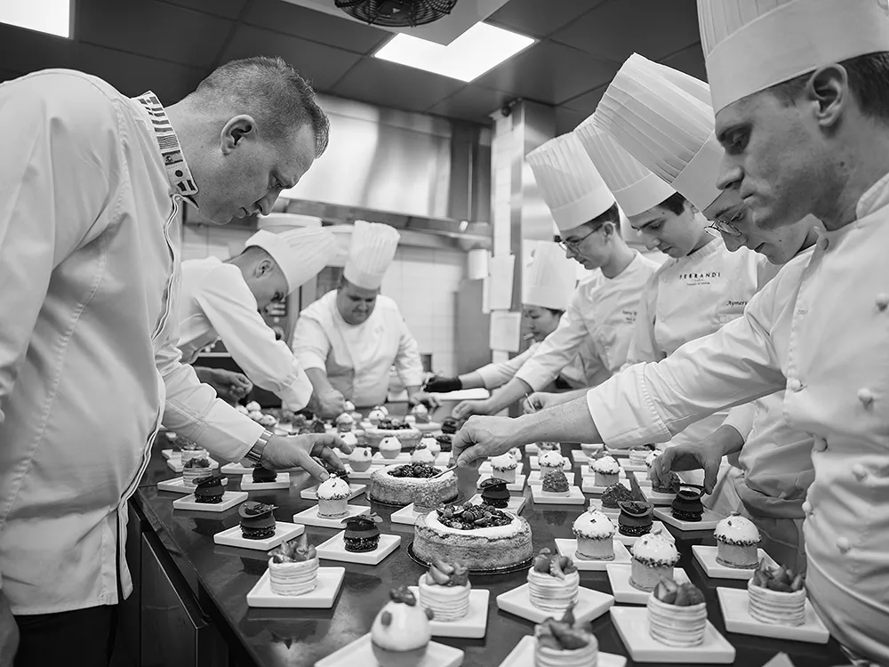 La brigade du restaurant Paul Bocuse dresse les desserts en série, toques et concentration, reportage photographe culinaire Lyon