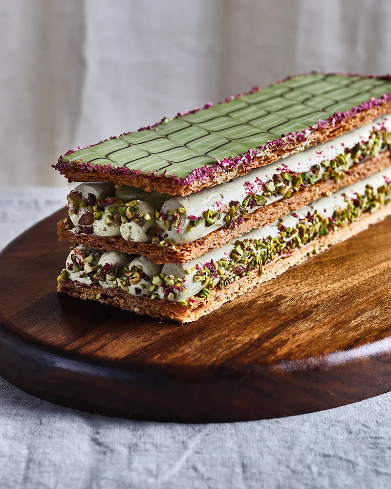 Mille-feuille à la pistache du chef Benoît Charvet sur planche de bois, photographie culinaire pour éditions Bocuse, photographe Lyon