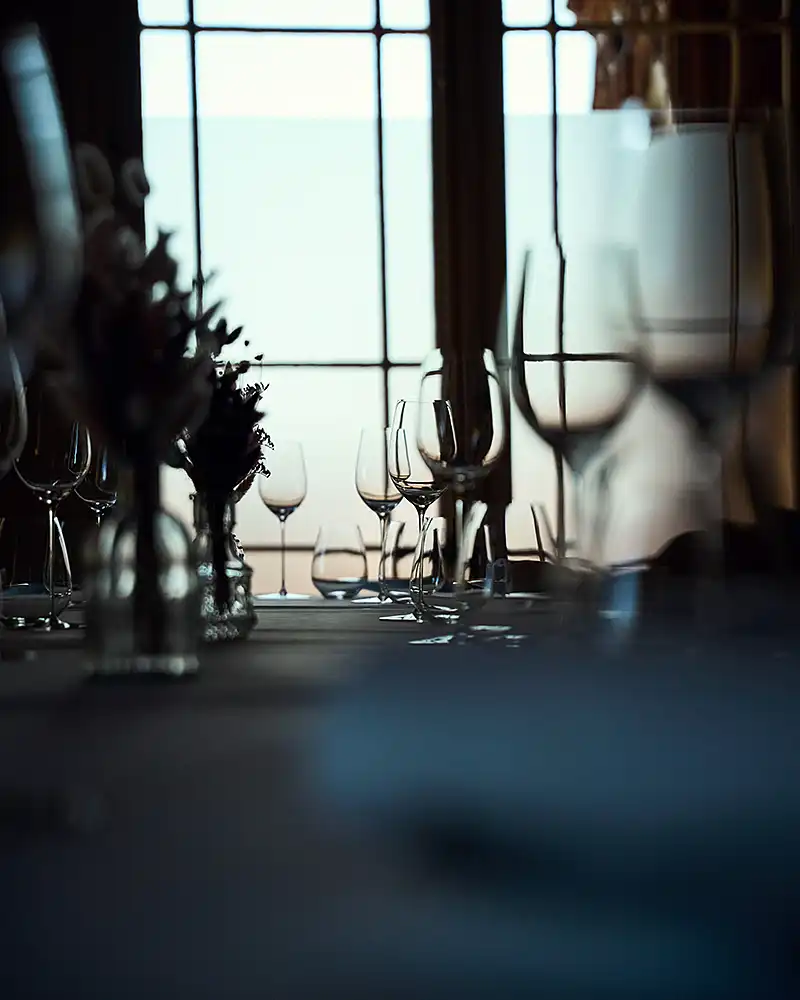 Verres en cristal dressés en contre-jour devant une fenêtre à meneaux, arts de la table, restaurant Saisons, photographe culinaire Lyon